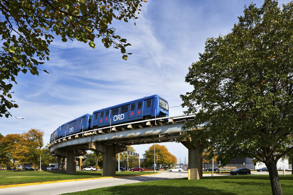 A blue train on a bridge.
