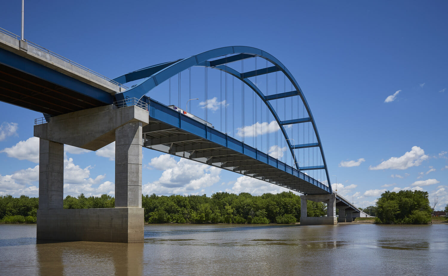 A blue bridge spanning over a river.