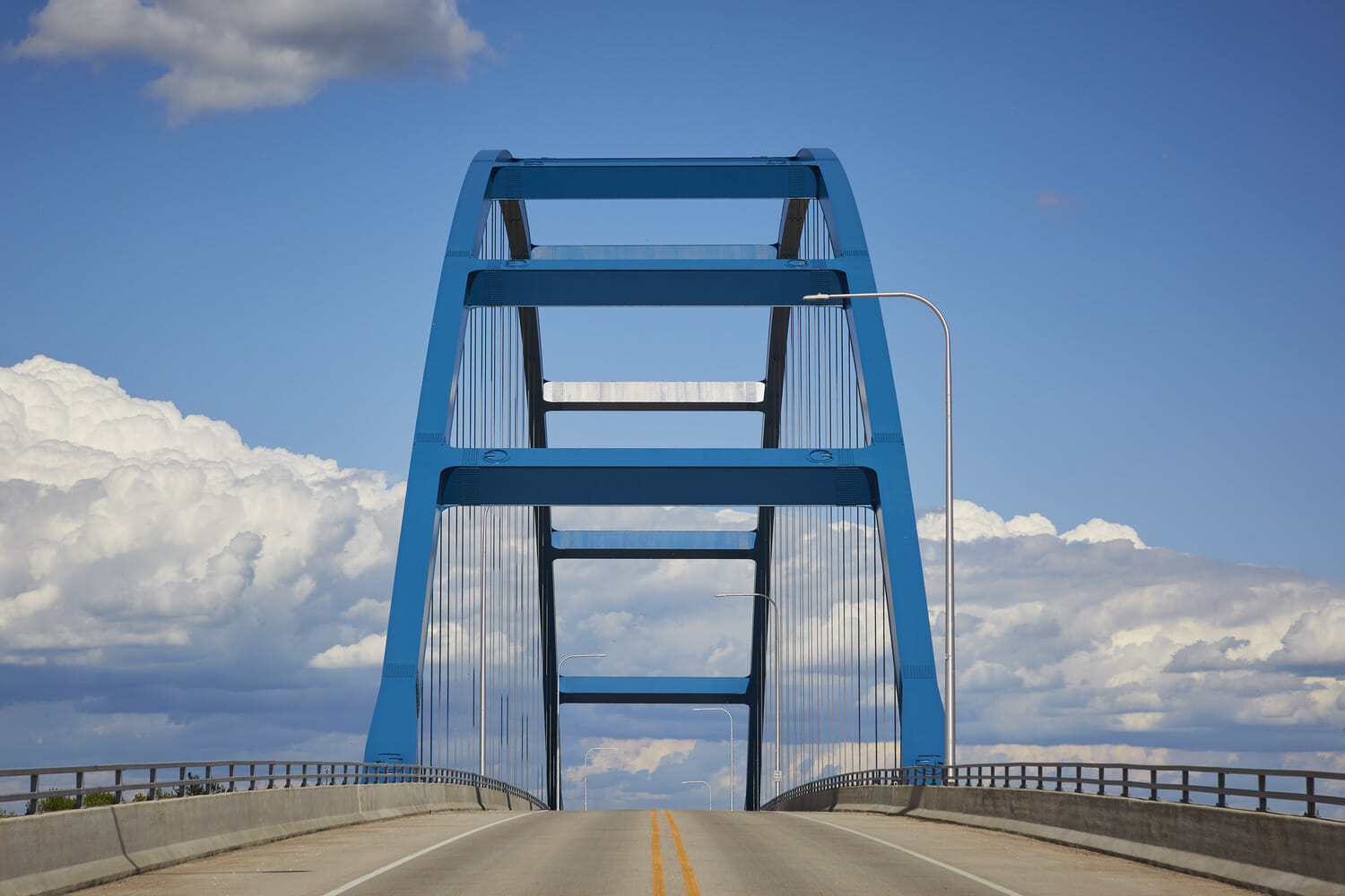 A blue bridge over a highway.