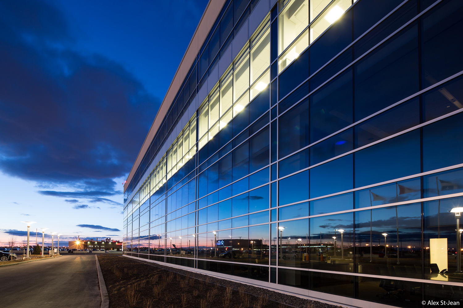 Un grand bâtiment de verre au crépuscule.