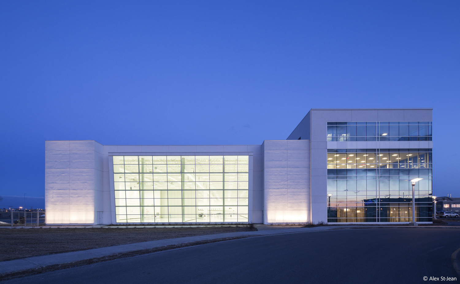 Un grand bâtiment blanc éclairé la nuit.