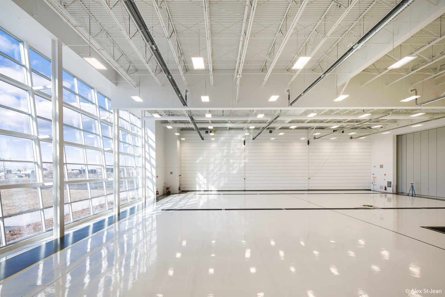 A large white room with windows and a white floor.