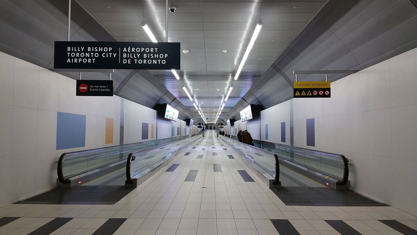 A long hallway with escalators and signs.