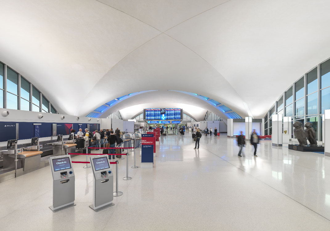 The inside of an airport with many people walking around.