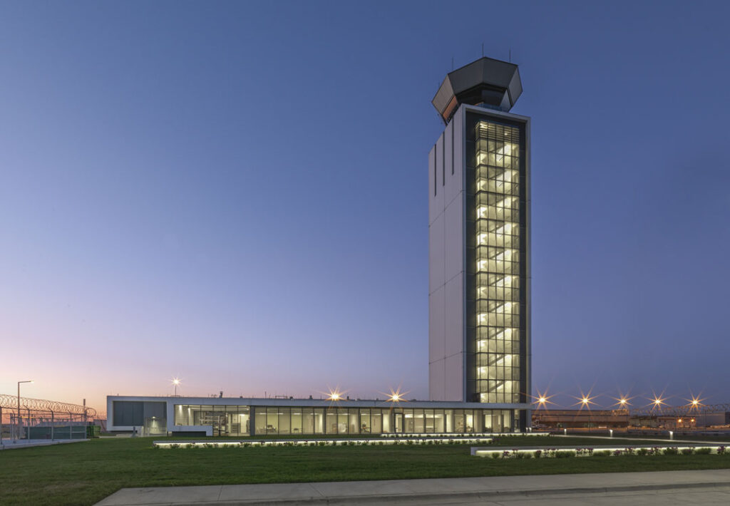 An airport control tower at dusk.