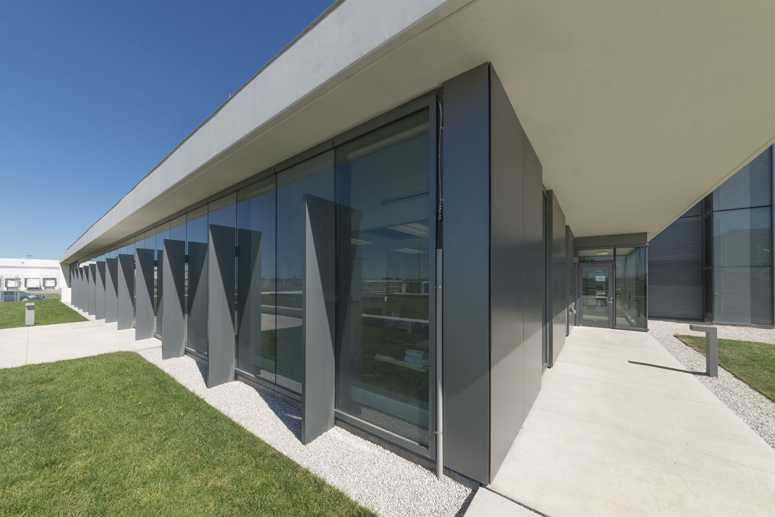 L'extérieur d'un bâtiment moderne avec une zone herbeuse.