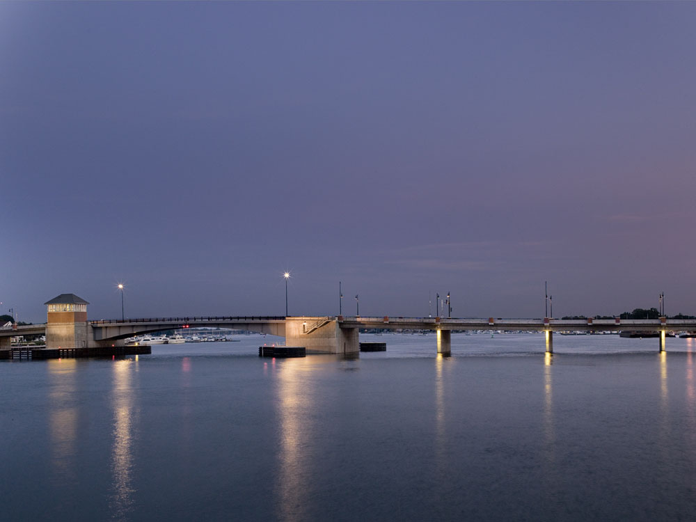 A bridge over a body of water at dusk.