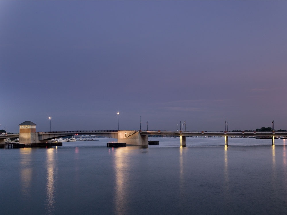 Un pont sur un plan d'eau au crépuscule.