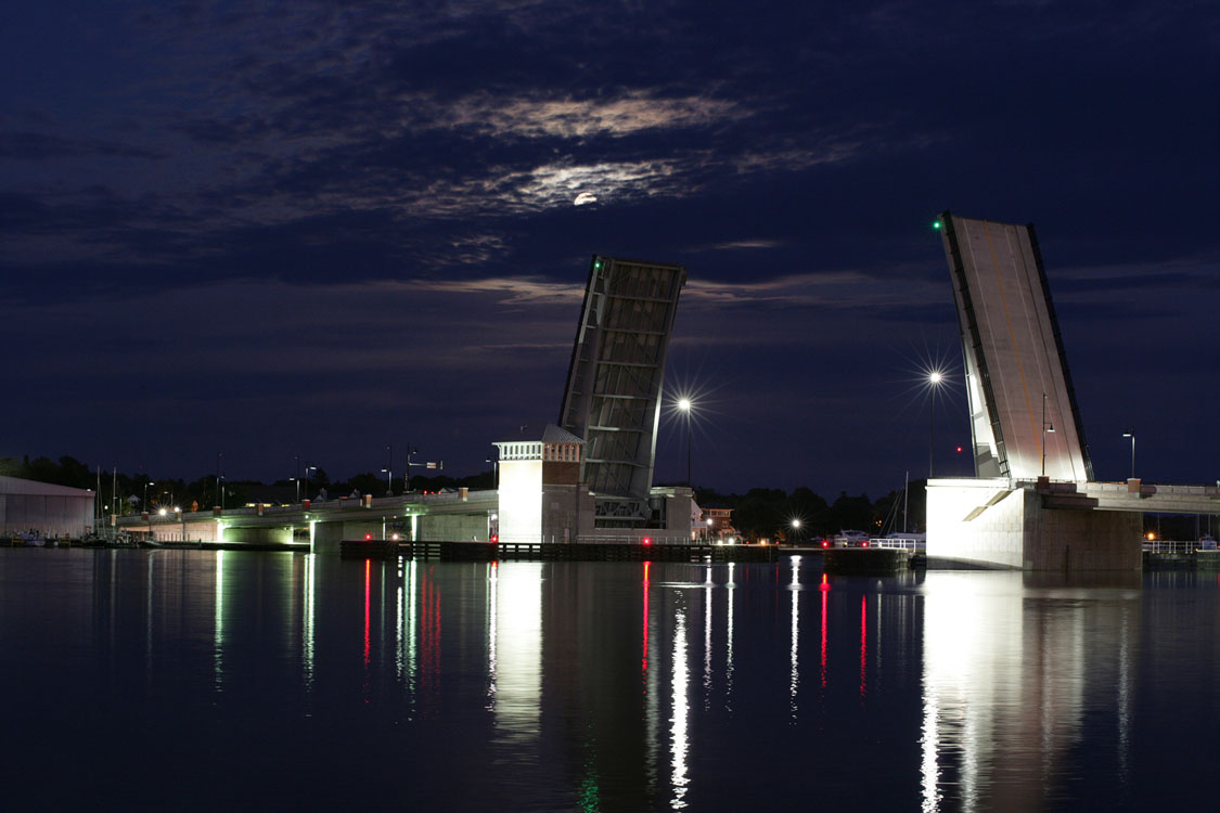A bridge over a body of water at night.