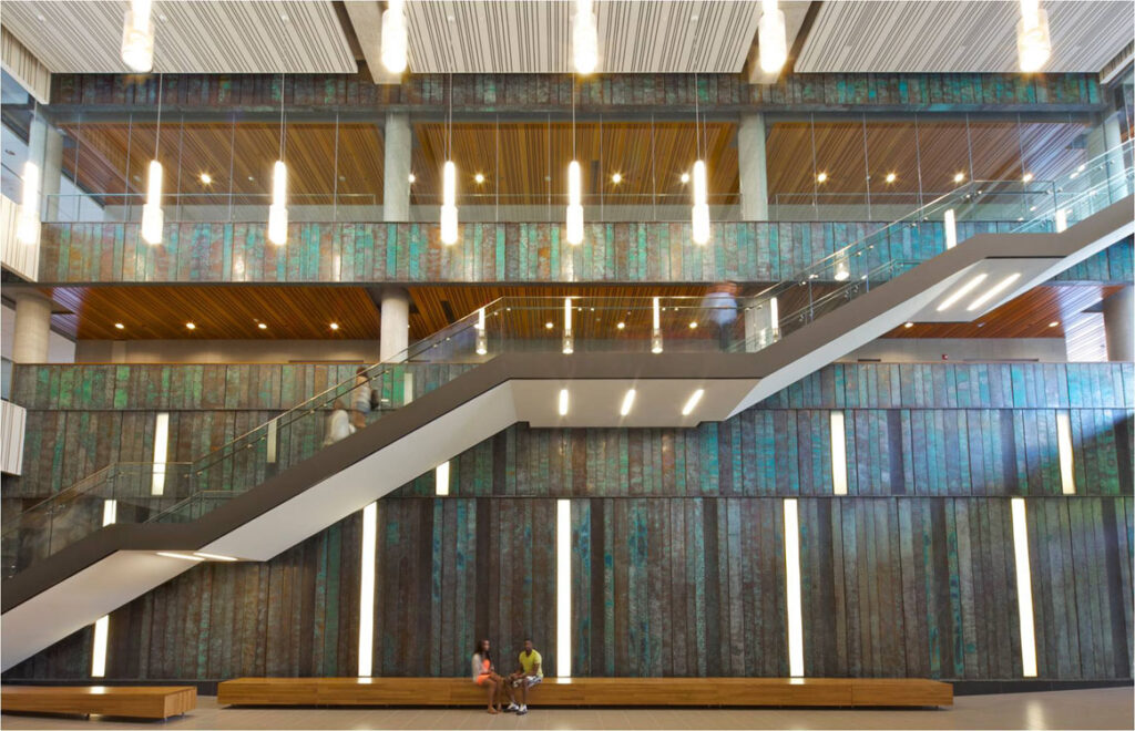The lobby of a building with stairs and a glass wall.