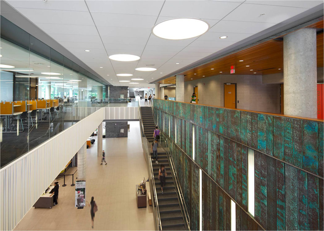 The atrium of a building with stairs and glass walls.