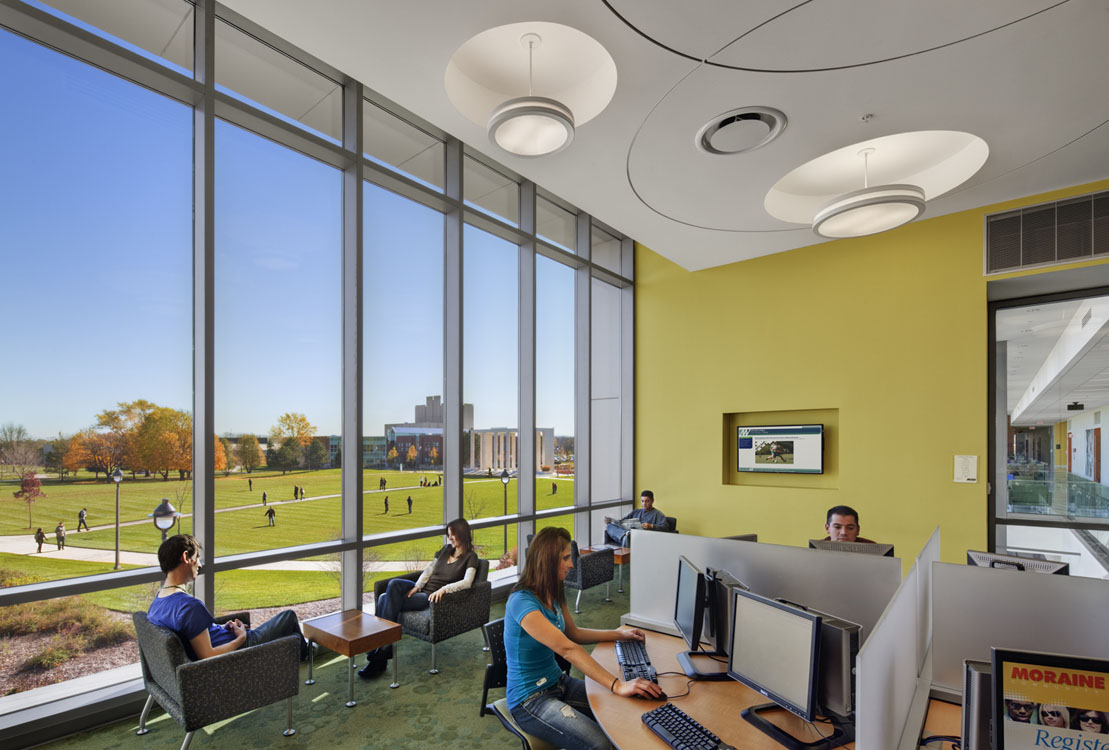 A group of people sitting at desks in a large open space.