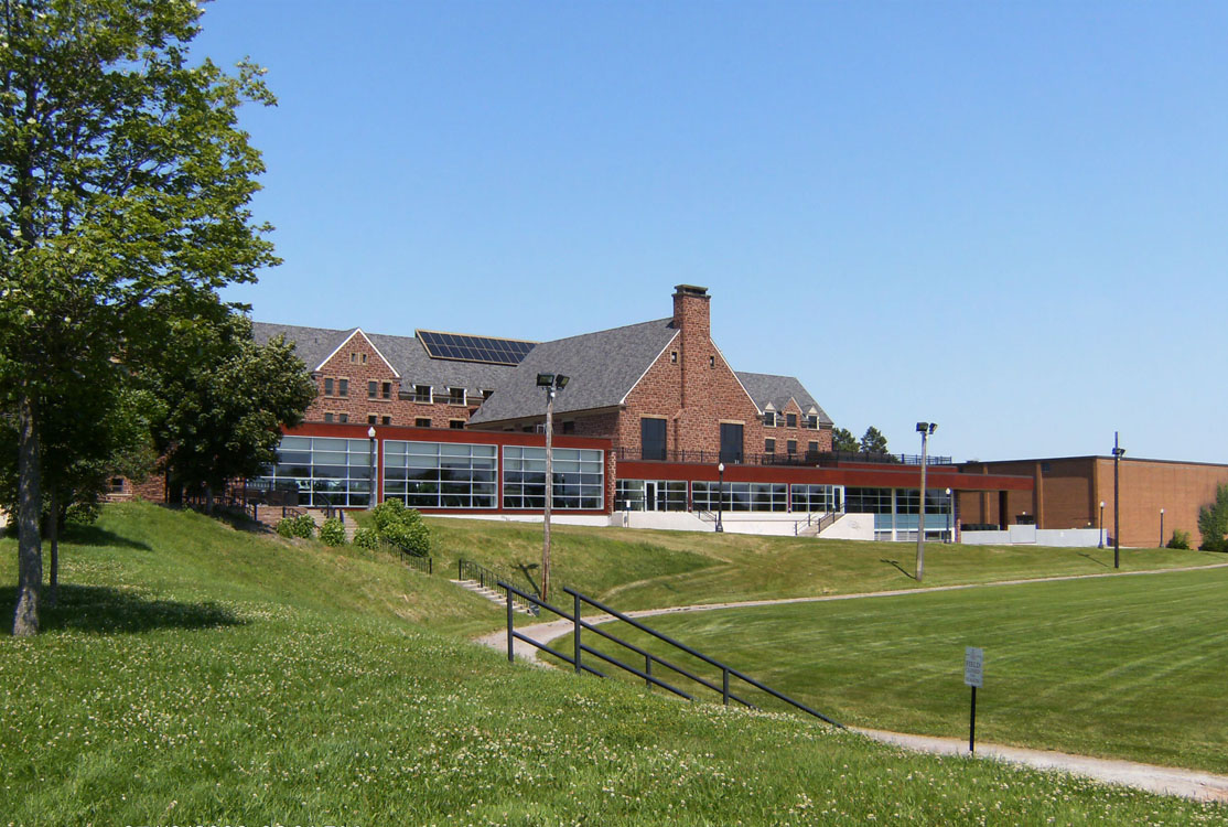 A grassy field with a building in the background.