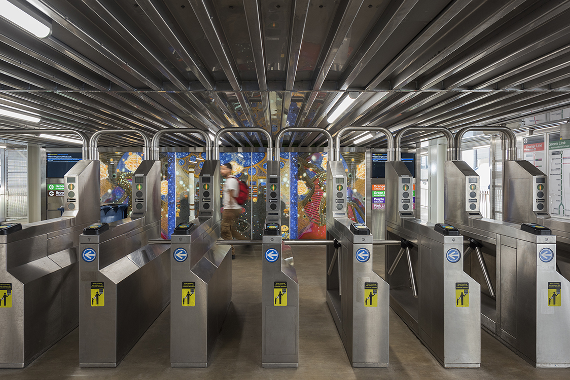 A long line of metal gates in a train station.