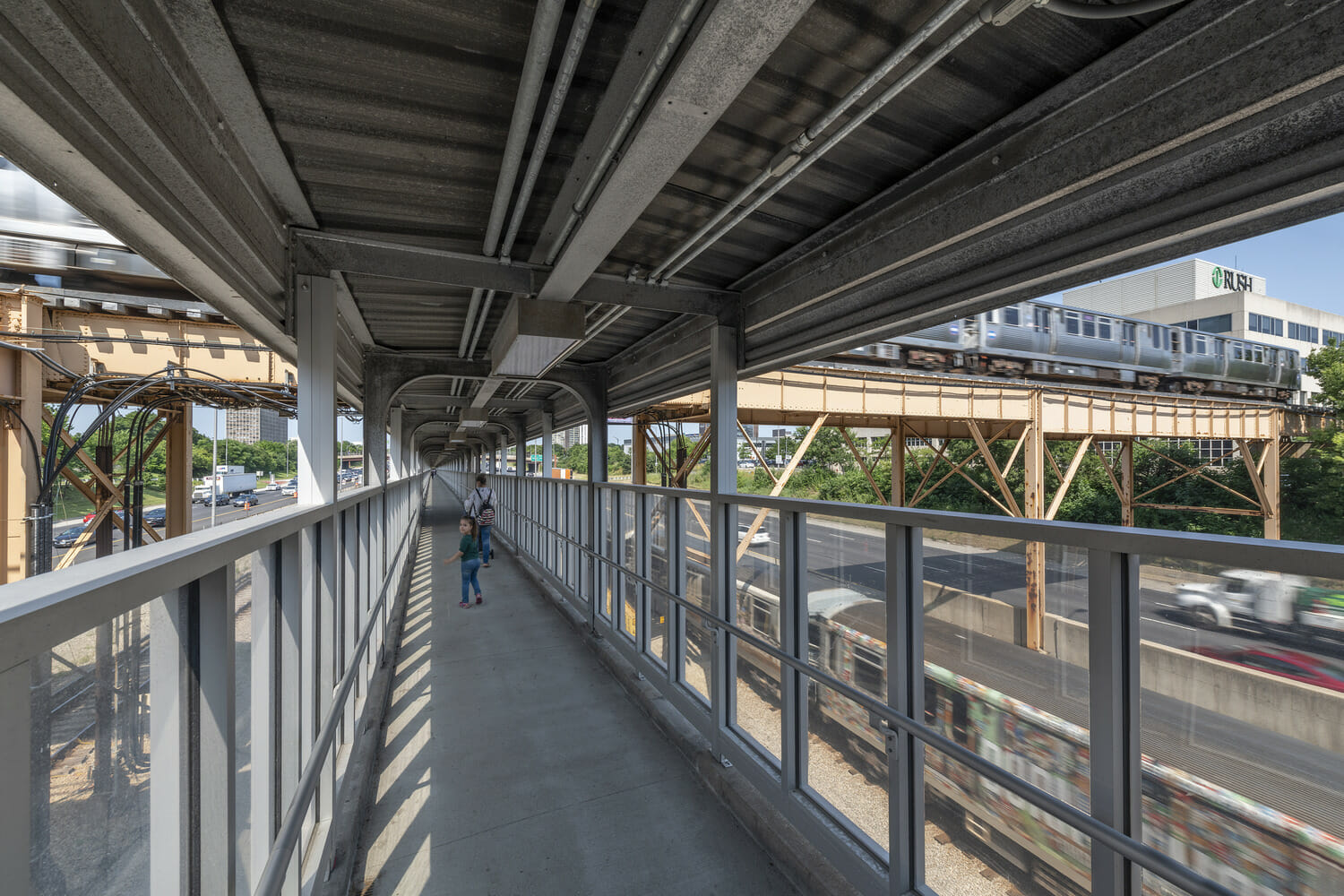 A person is walking on a walkway next to a train.