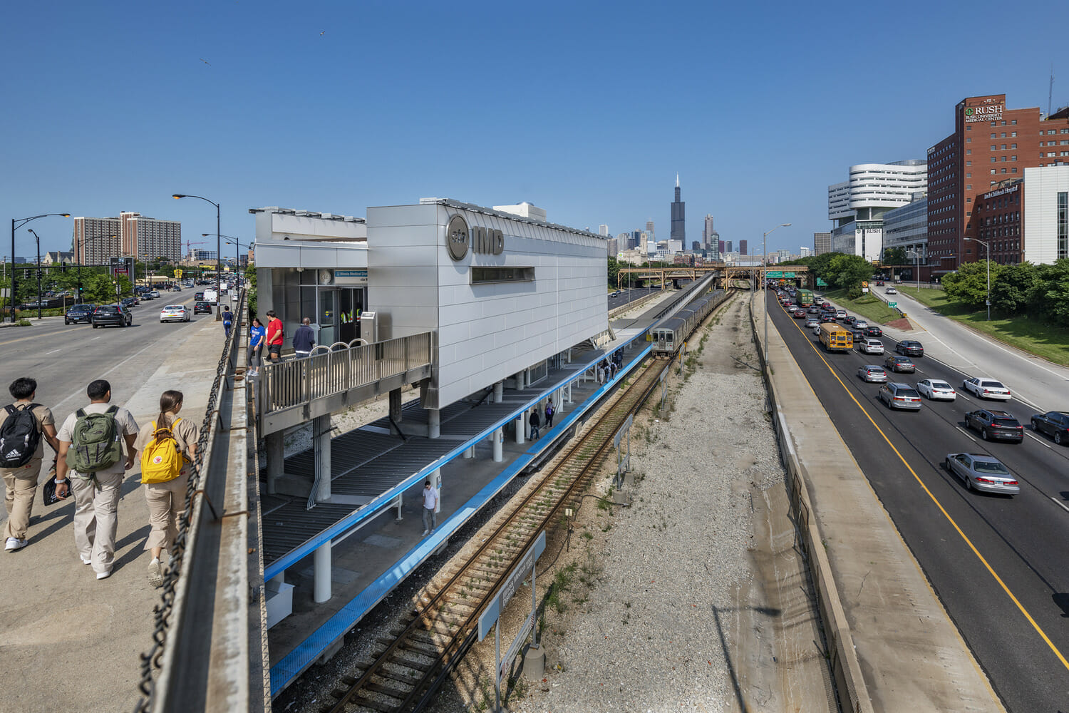 A group of people walking on a bridge over a city.