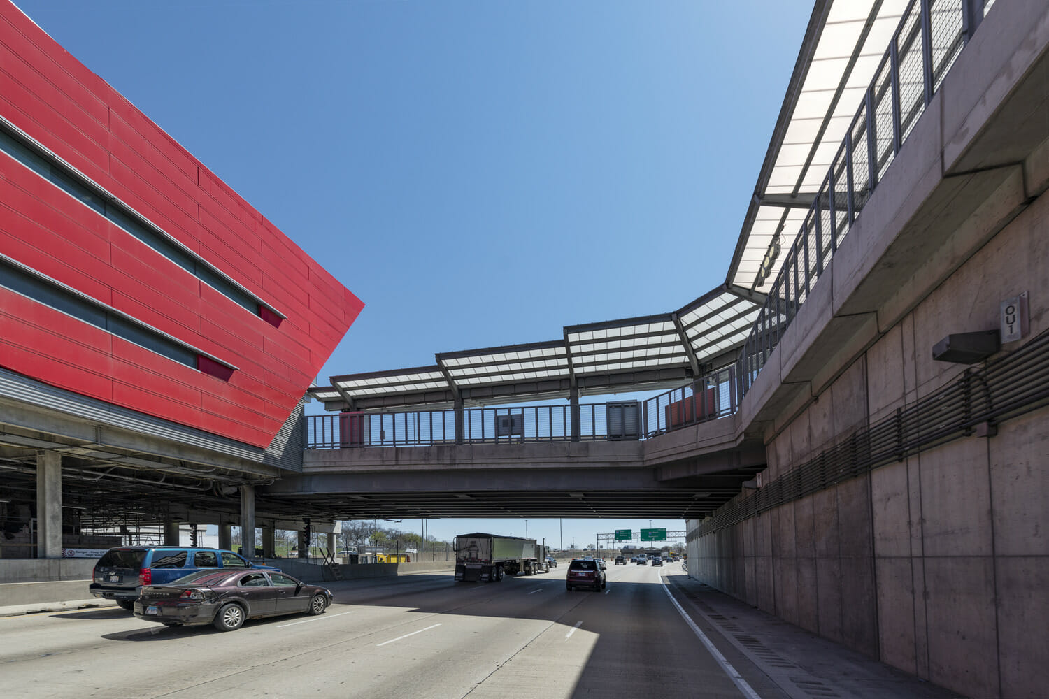 An overpass with a red roof and cars on the road.