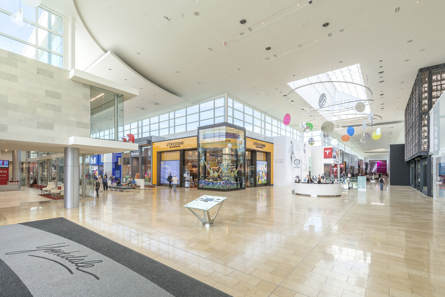 The interior of a shopping mall with a lot of people.