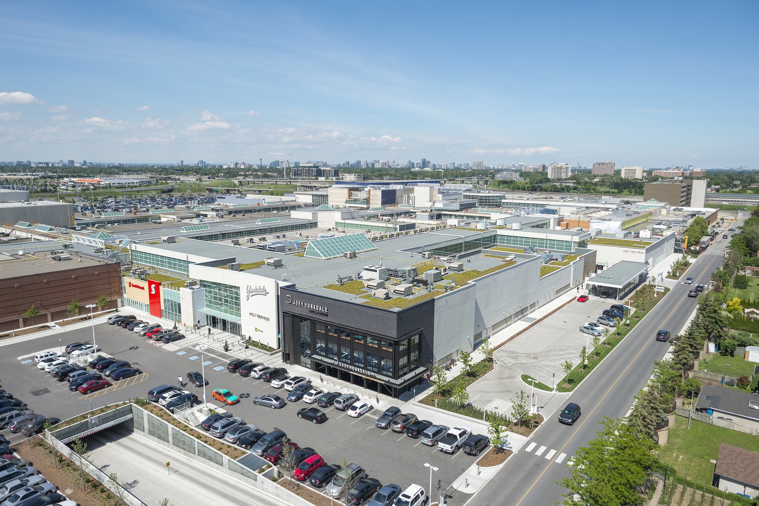 An aerial view of a shopping mall with cars parked in the parking lot.