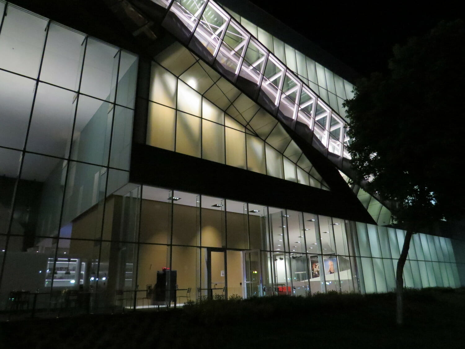 A large glass building lit up at night.