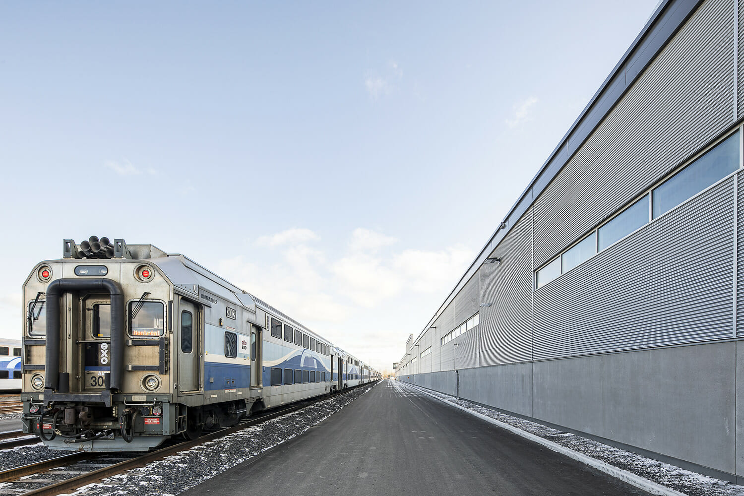 A train on the tracks next to a building.