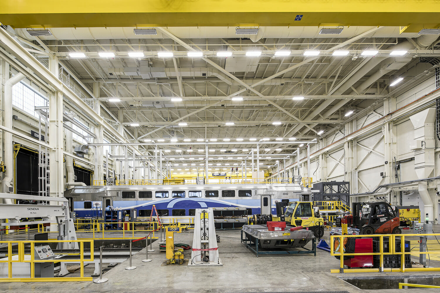 A blue and yellow train in a warehouse.