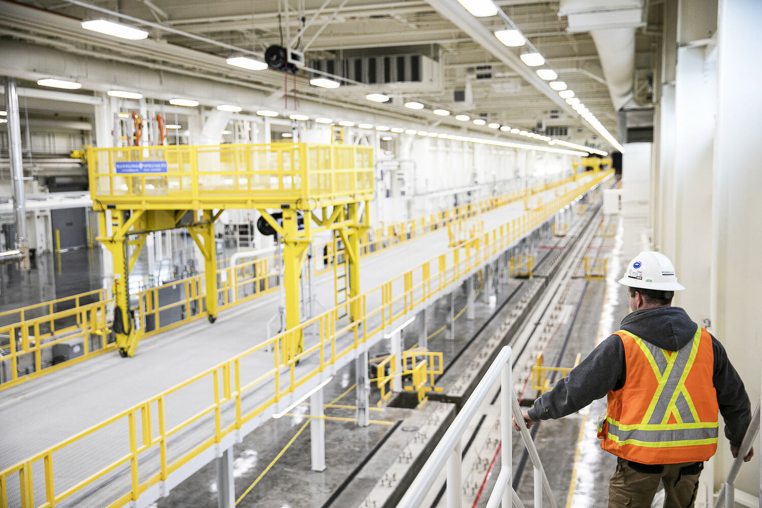 A worker standing on a conveyor belt in a factory.