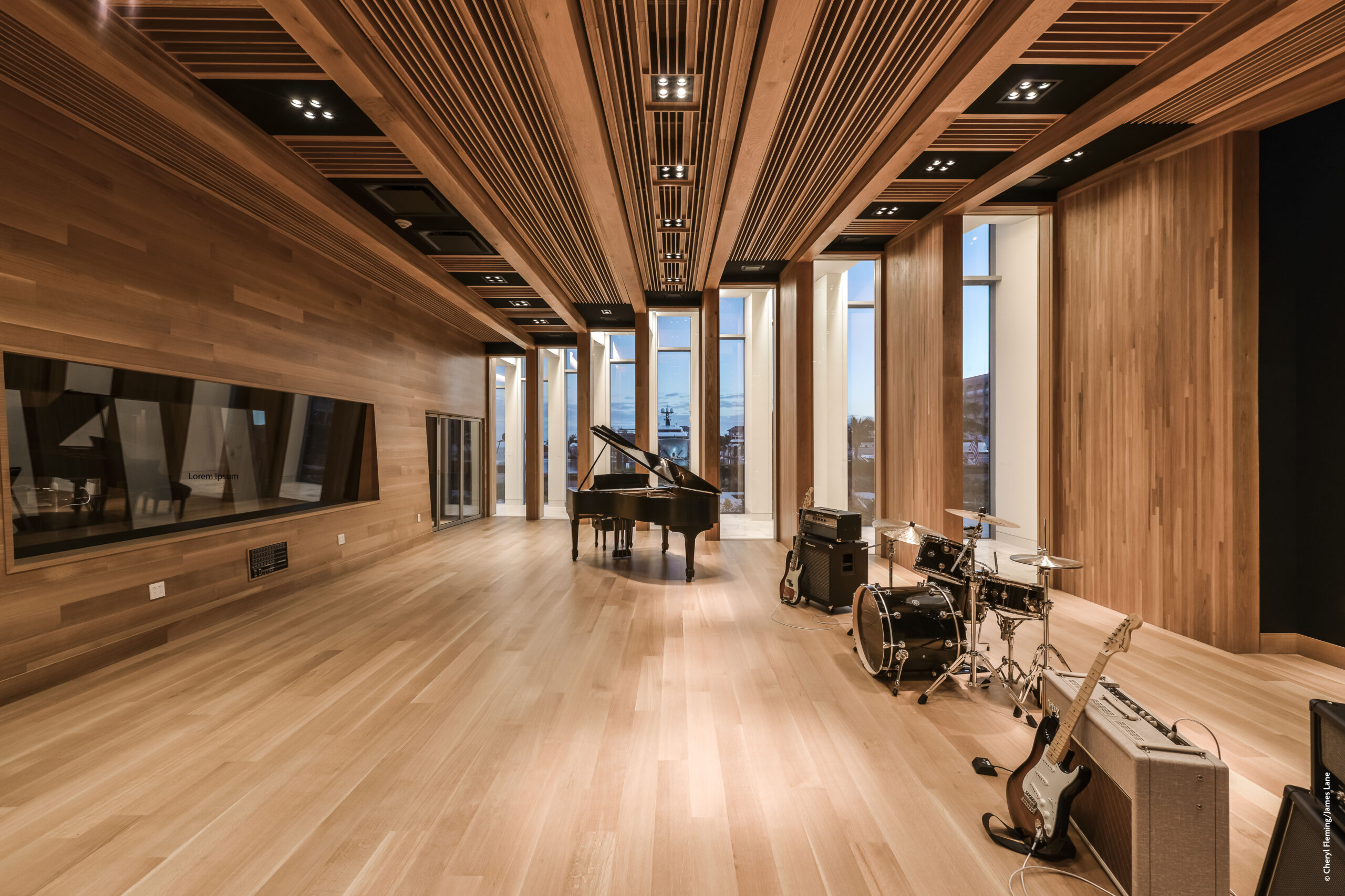 A recording studio with wooden walls and a guitar.