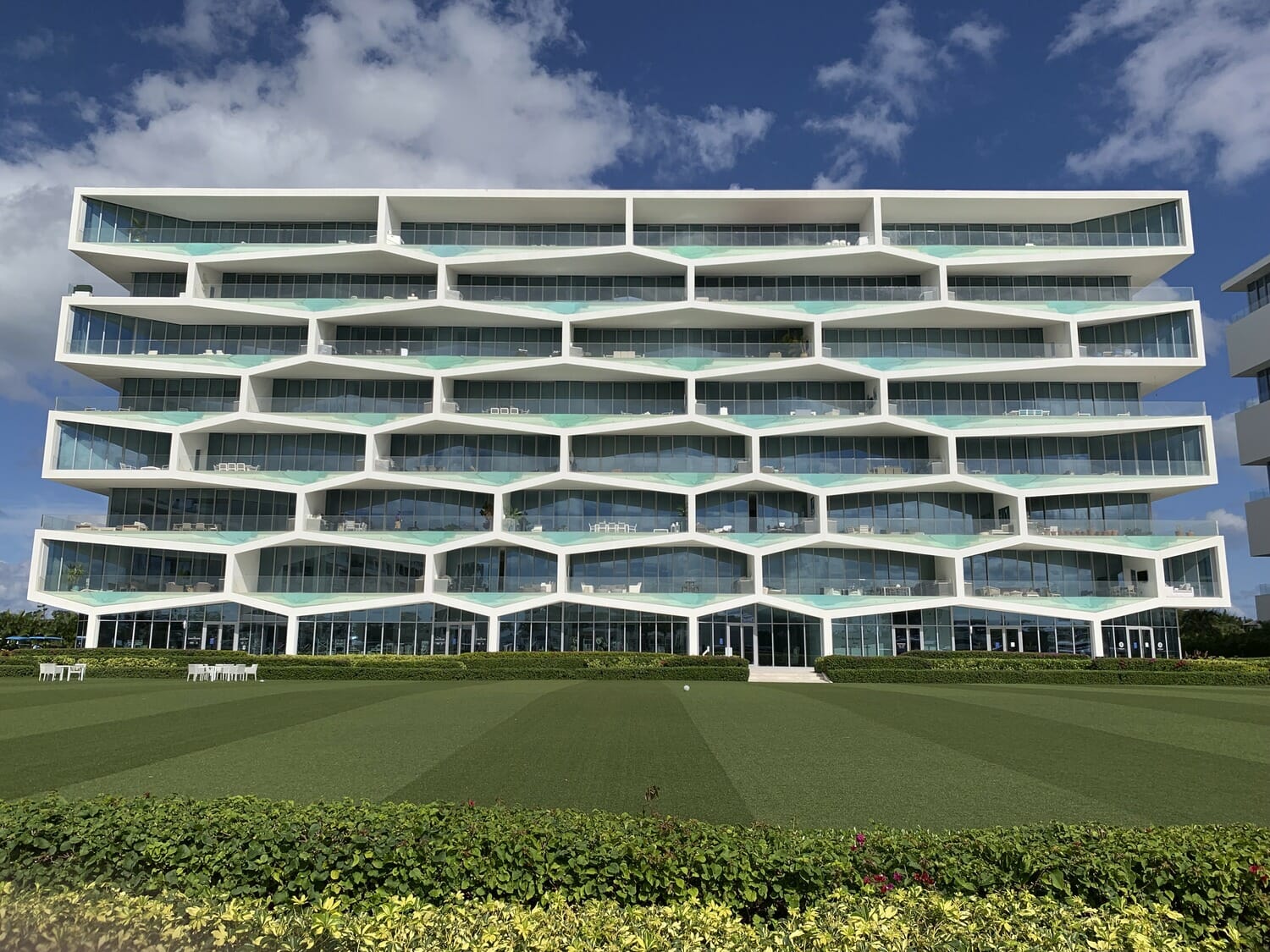 A modern office building in the middle of a grassy field.