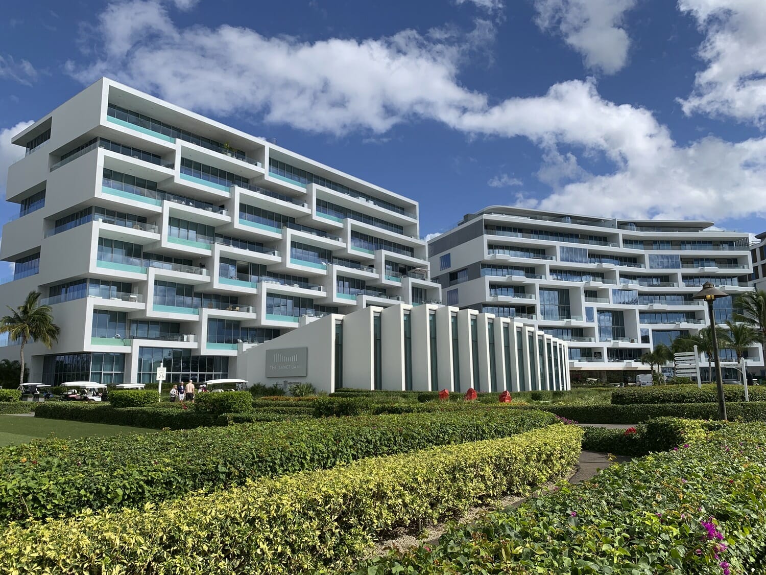 A rendering of an apartment building with a green lawn.