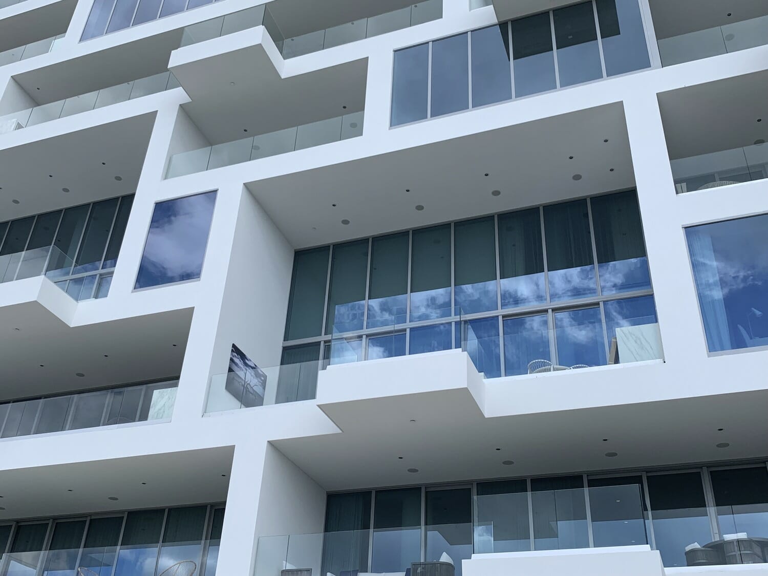 3d rendering of a white building with balconies and windows.