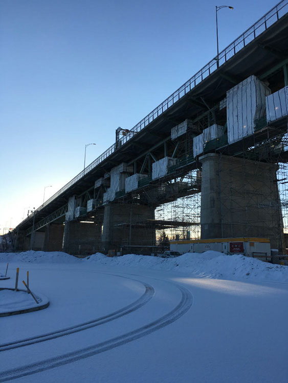 A bridge under construction with snow on the ground.