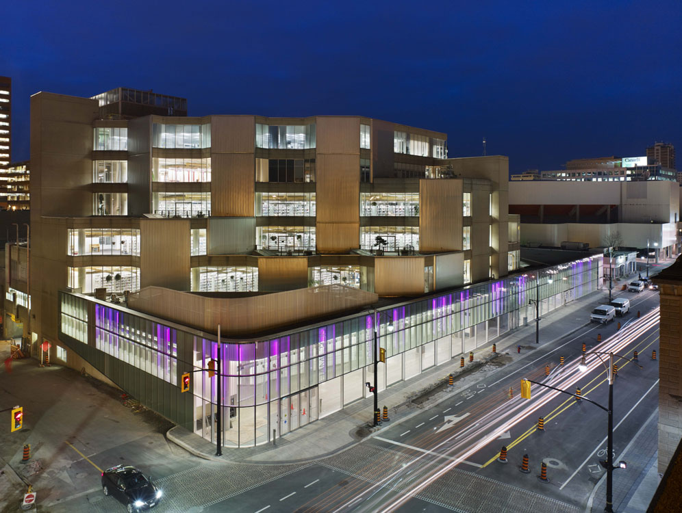 Un bâtiment la nuit avec une lumière violette qui brille dessus.