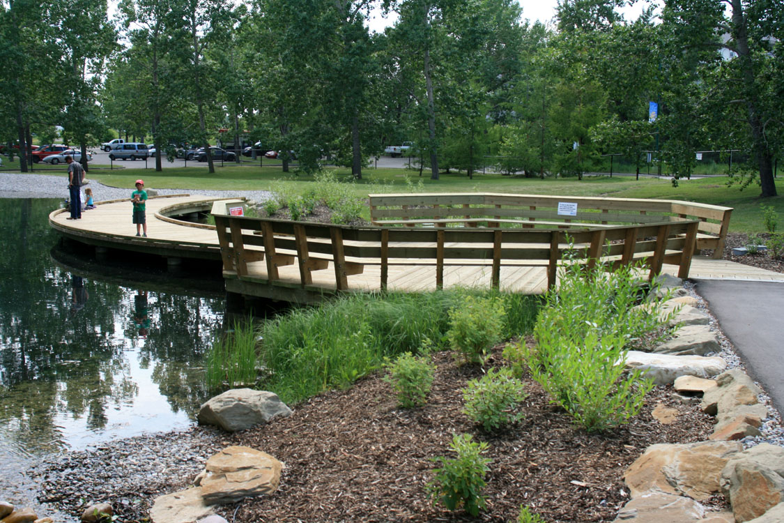 A wooden bridge over a pond.