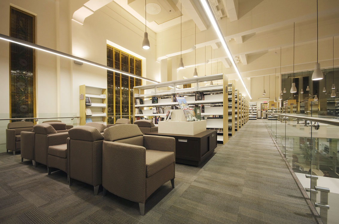 The interior of a library with bookshelves and chairs.