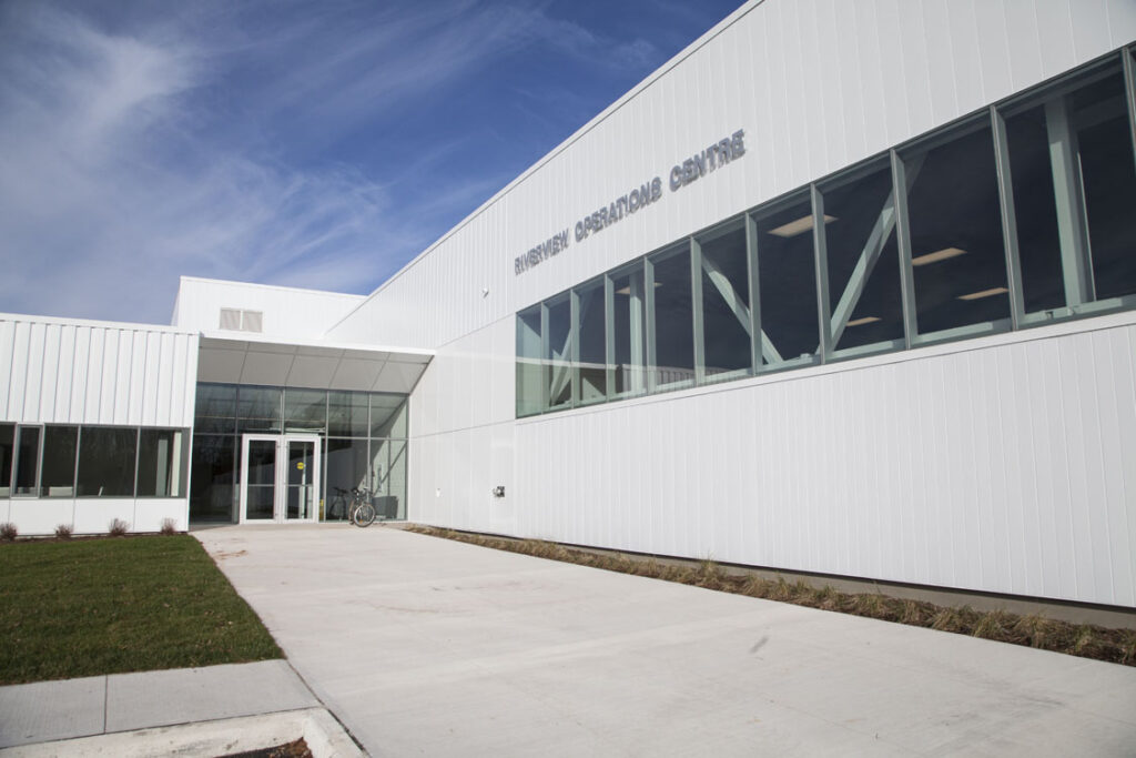 The entrance to a white building with a grassy area.