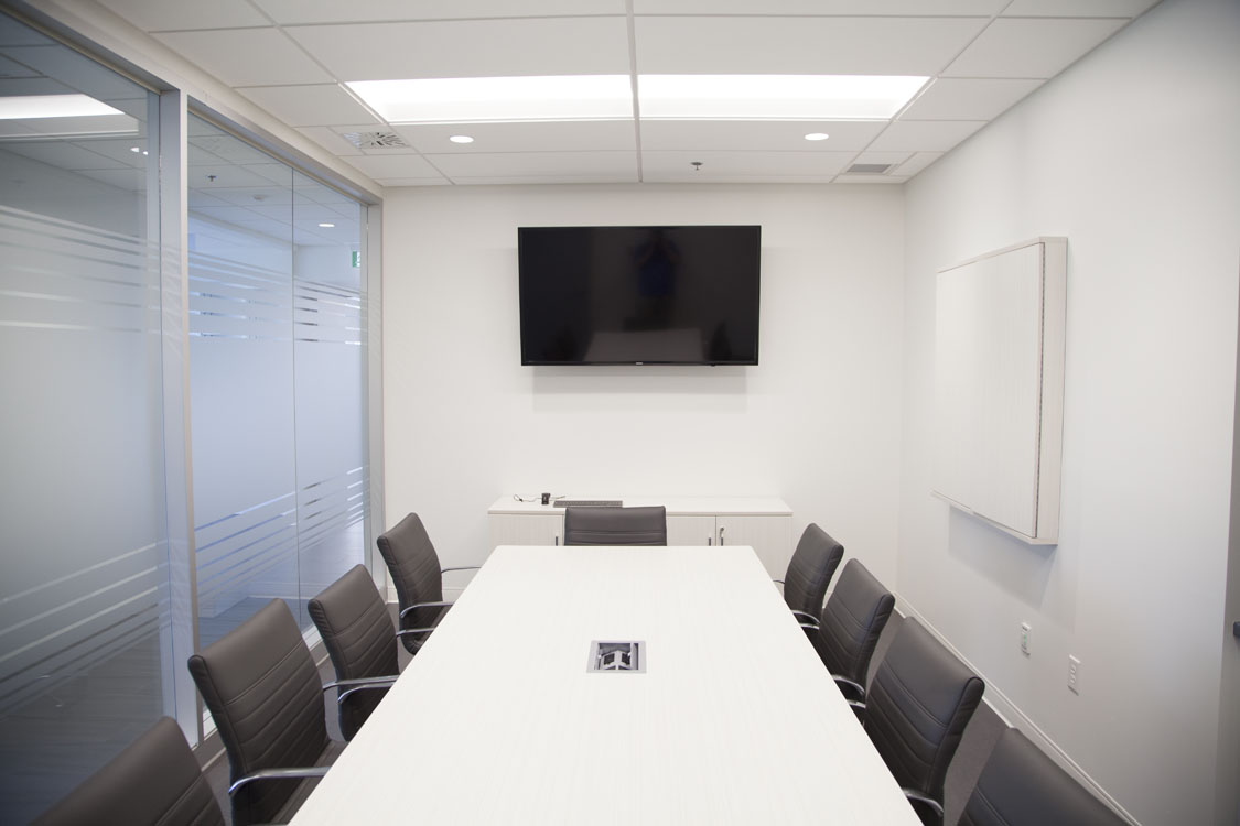 A conference room with a white table and chairs.