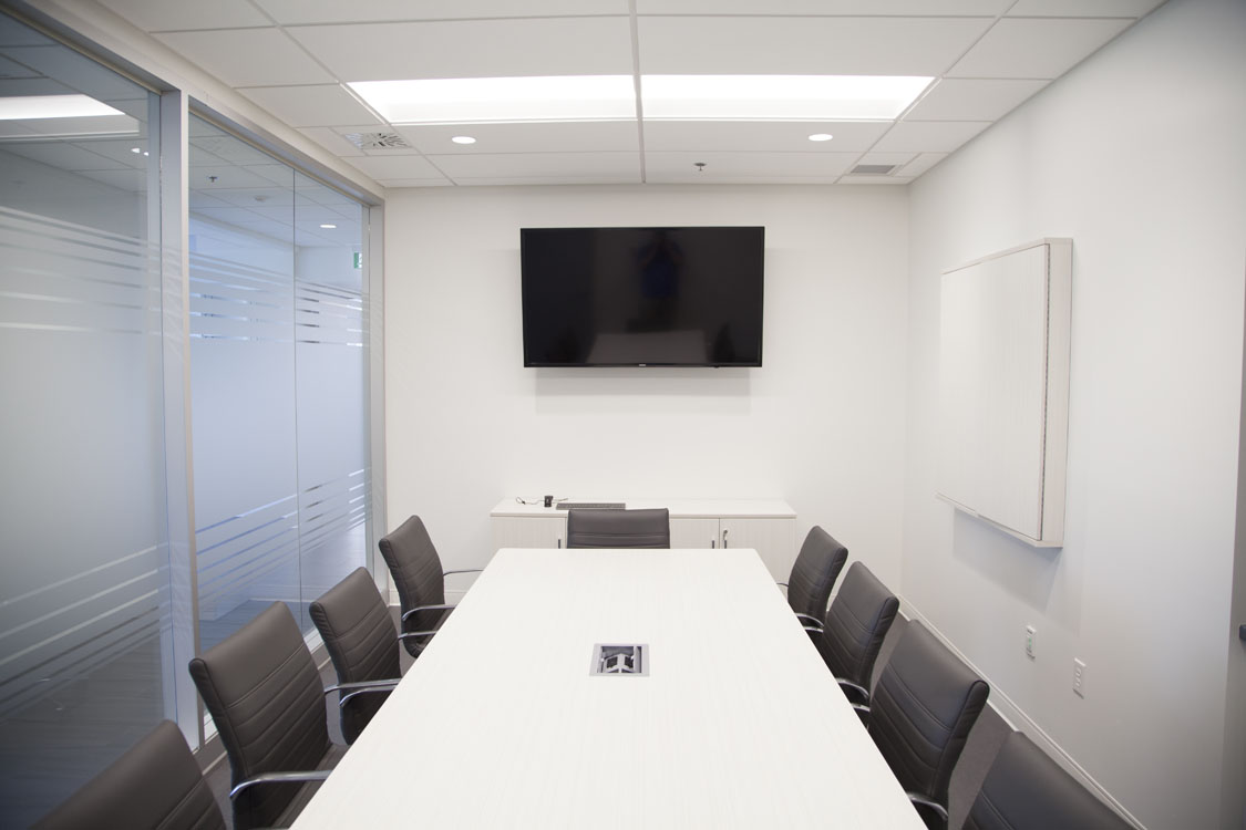 Une salle de conférence avec une table et des chaises blanches.