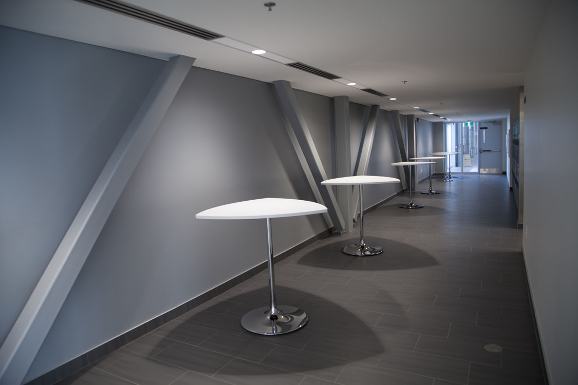 A hallway with tables and chairs in it.