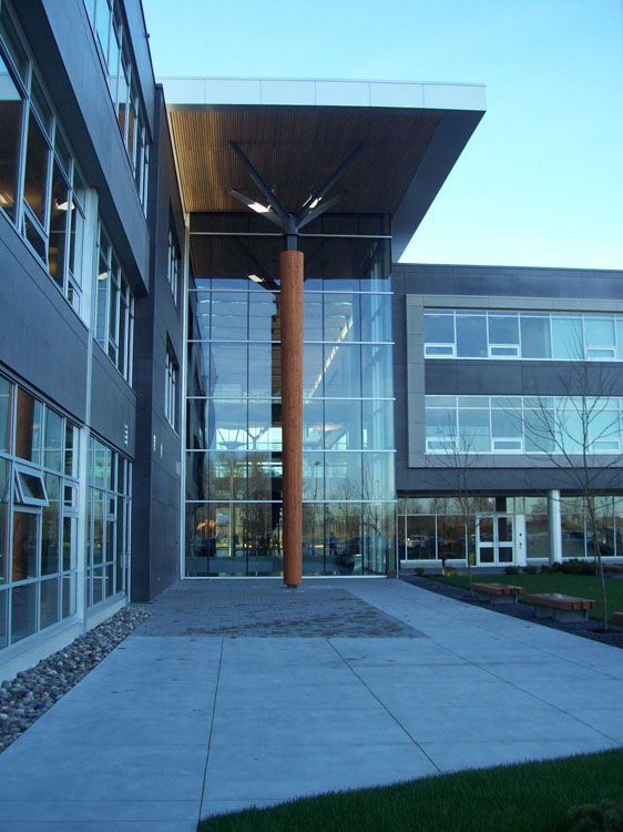 A glass building with a wooden pole.