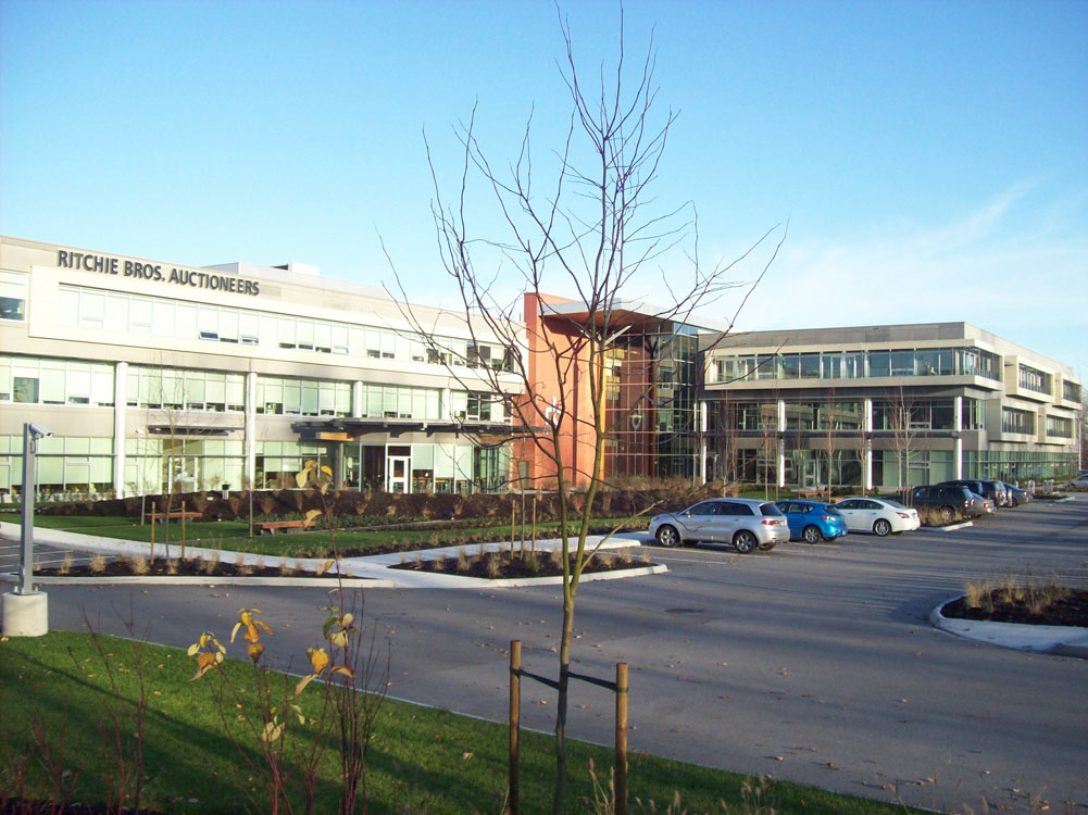 A parking lot with cars parked in front of a building.