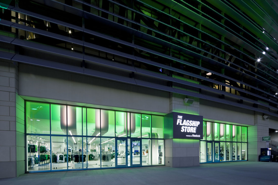 Un bâtiment avec une façade éclairée de vert la nuit.