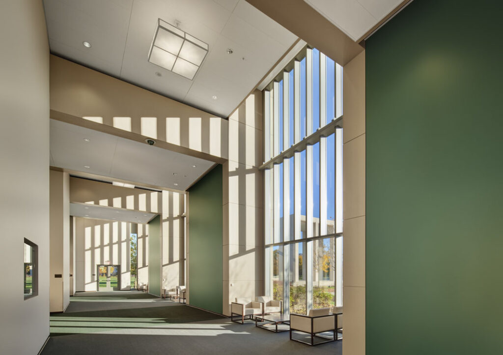 A hallway with large windows and green walls.