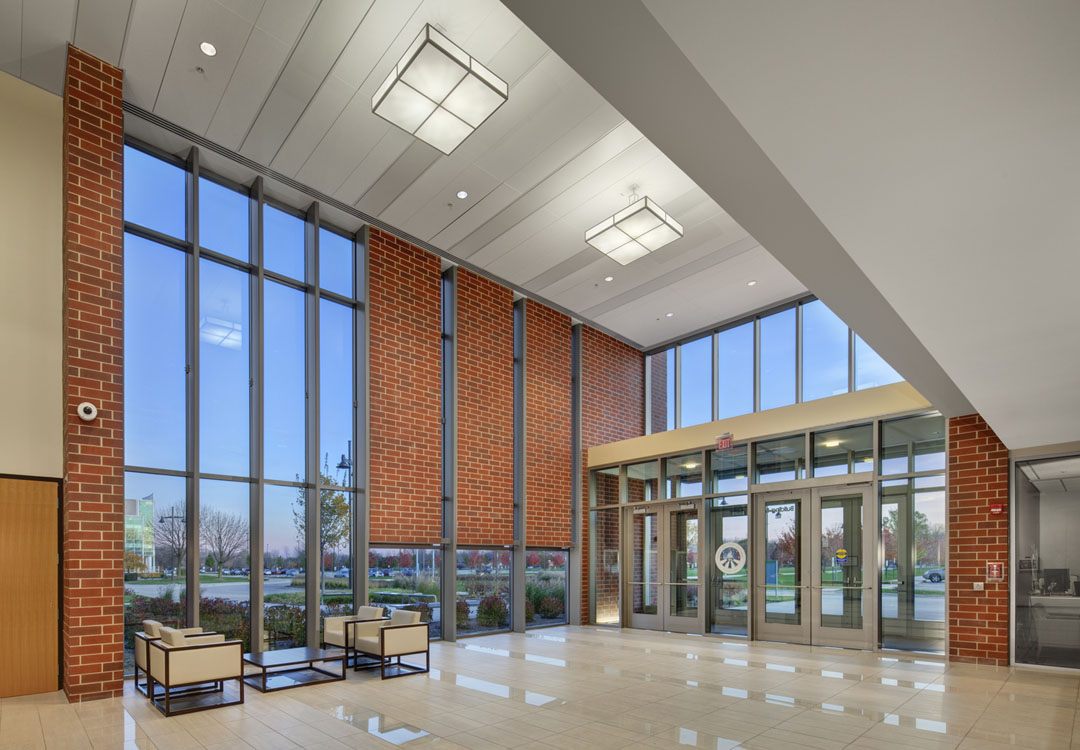 A lobby with large windows and brick walls.