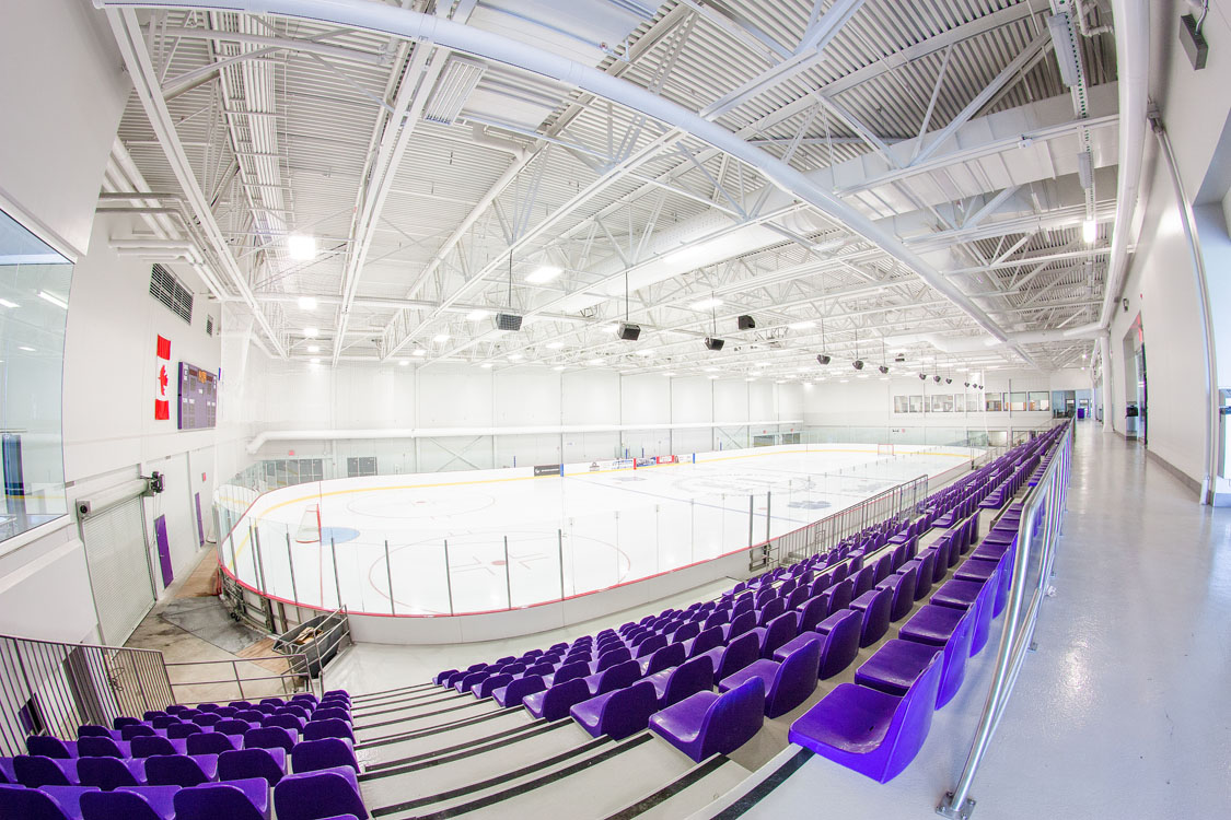 Une patinoire couverte avec des sièges violets.