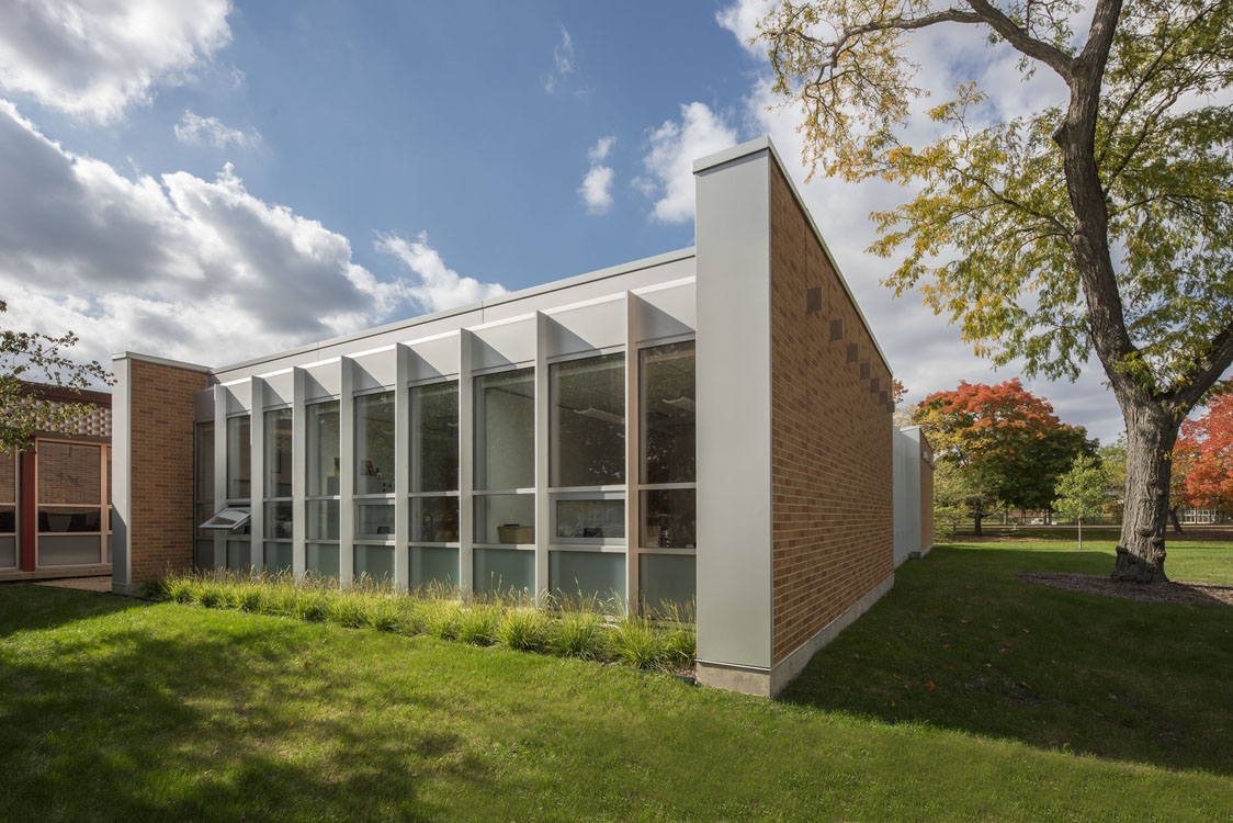 The exterior of a school building with glass windows.