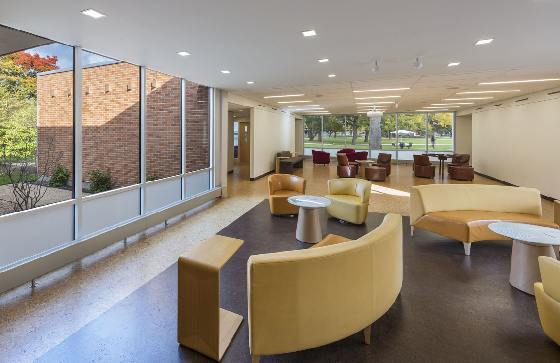 A lobby with yellow chairs and a large window.