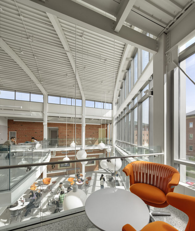 Une chaise orange se trouve dans un bureau en verre.