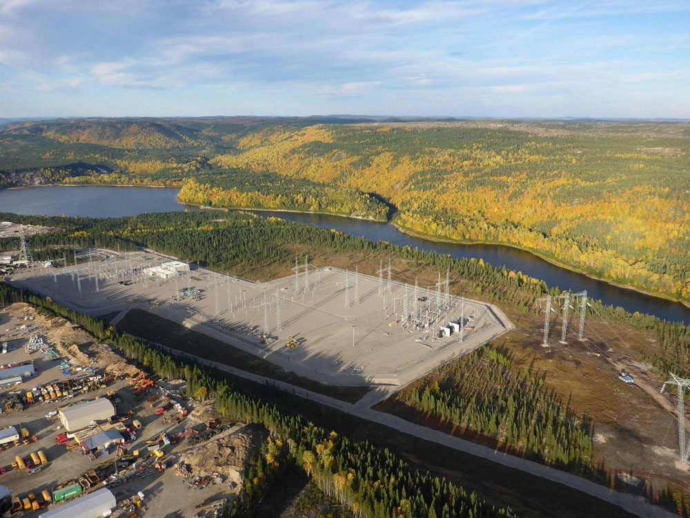 An aerial view of a power plant near a river.