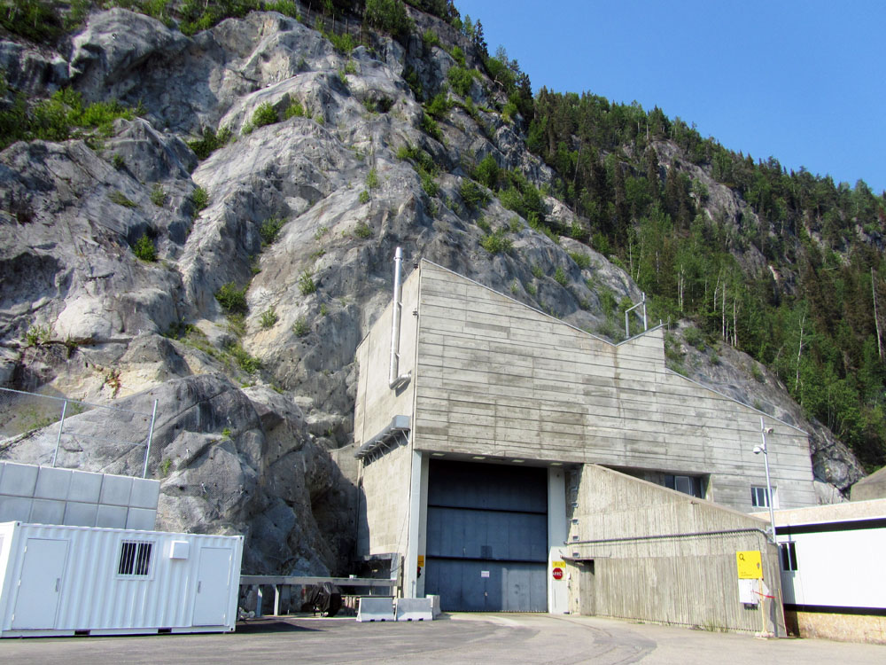 A large concrete building next to a mountain.